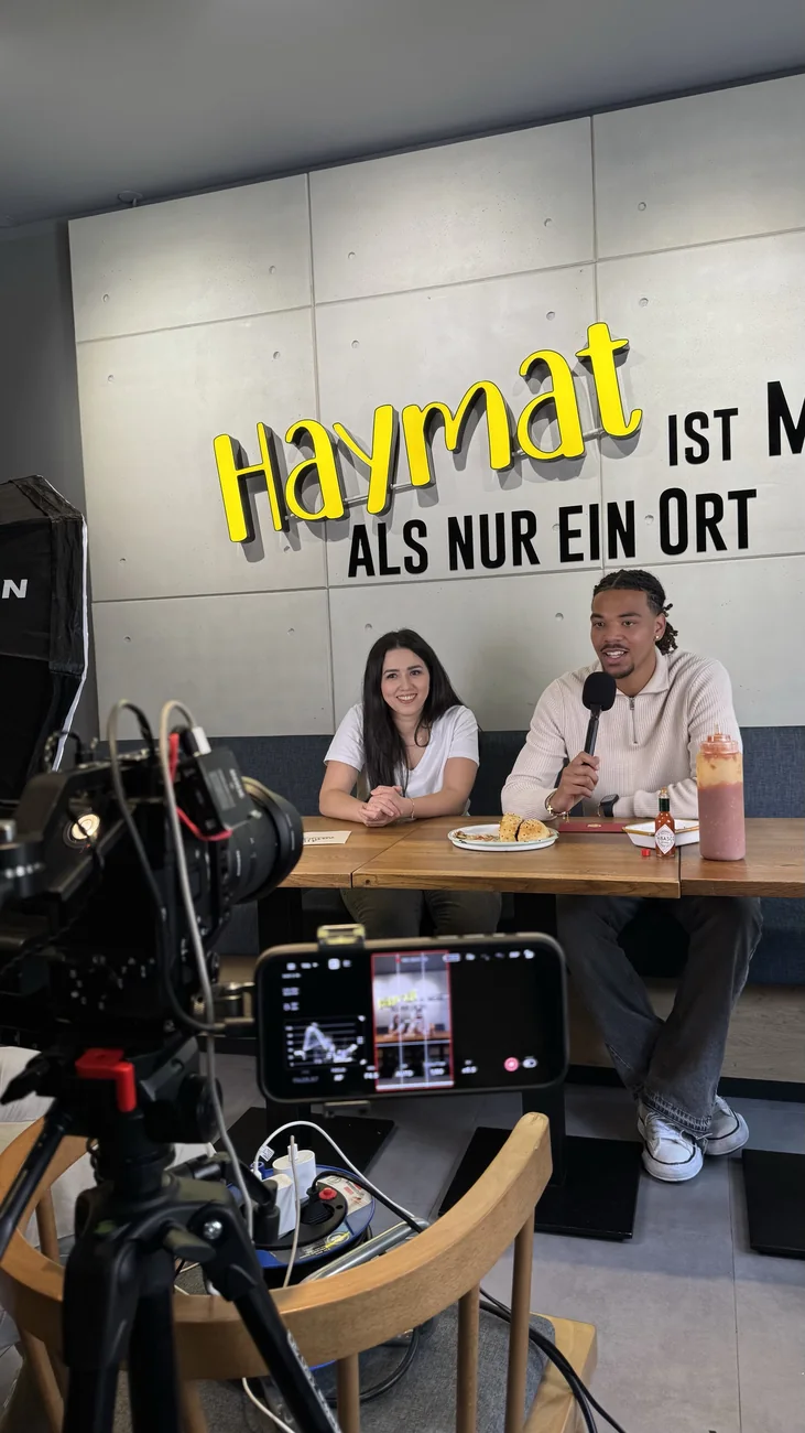 Interview-Dreh bei Haymat vor dem Haymat-Schriftzug